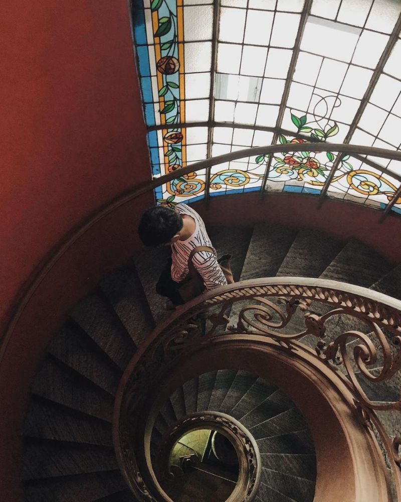 chàng trai đang bước xuống cầu thang hình xoắn ốc