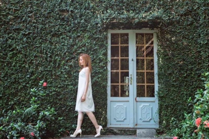 cô gái mặc đầm trắng bước đi trên phố vắng